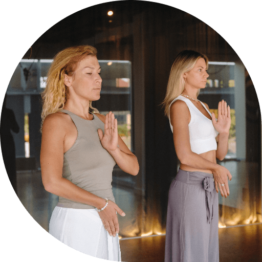 two-beautiful-women-are-doing-yoga-standing-up-fitness-room